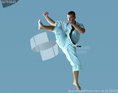 Image of Man in white kimono training karate