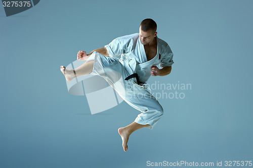 Image of Man in white kimono training karate