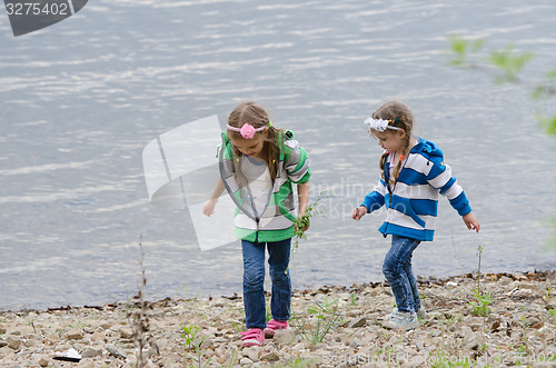 Image of Two children that is going on the river bank