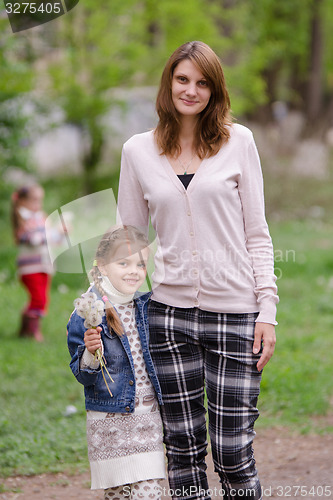 Image of Young woman a daughter with dandelions in hands