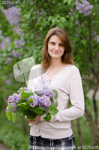 Image of Portrait young European girl with a lilac in the hands of