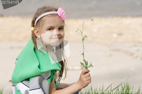 Image of Girl with blade of grass in hands