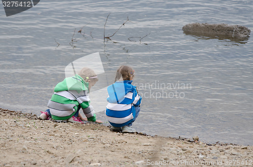 Image of Two girls sitting on a river bank