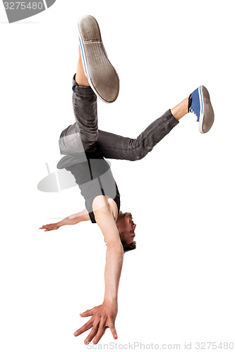 Image of Break dancer doing one handed handstand against a white background