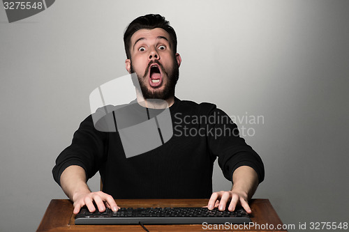 Image of Crazy businessman sitting at table
