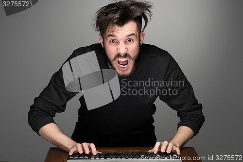 Image of Crazy businessman sitting at table