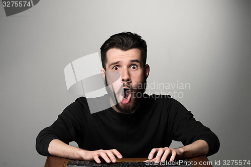 Image of Crazy businessman sitting at table