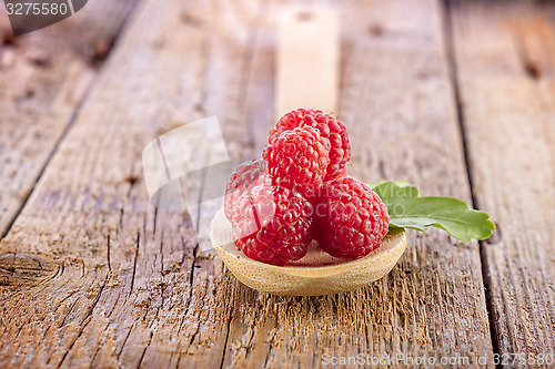 Image of fresh berries in wooden spoon on wooden table