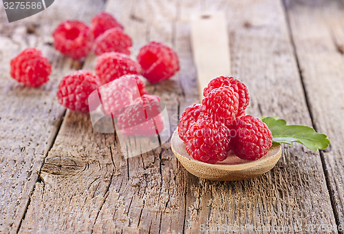 Image of fresh raspberry in wooden spoon on wooden table