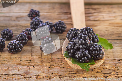 Image of blackberries with spoon on wooden background