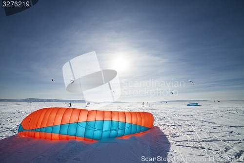 Image of Kiteboarder with blue kite on the snow