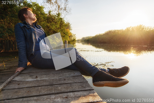 Image of Woman relaxing on jetty