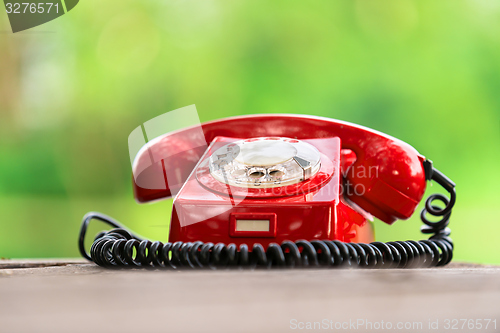 Image of Red phone on wooden deck