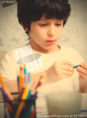 Image of boy chooses a pencil