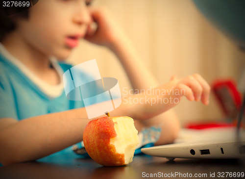 Image of bitten apple and a boy with computer