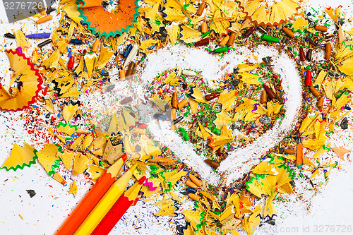 Image of heart, three pencils and colored wooden shavings