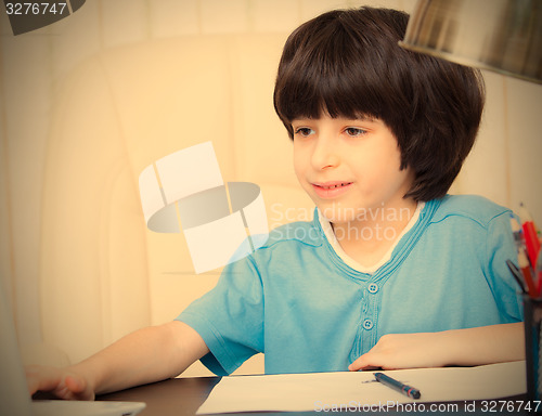 Image of boy doing homework with computer