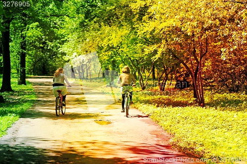 Image of Two girls ride bikes  