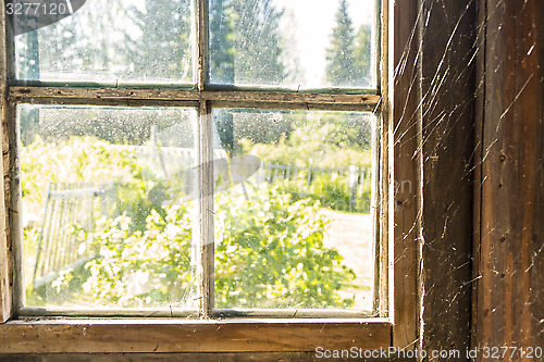 Image of Old window with spiderweb 