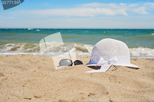 Image of Wicker white hat and sun glasses on the beach