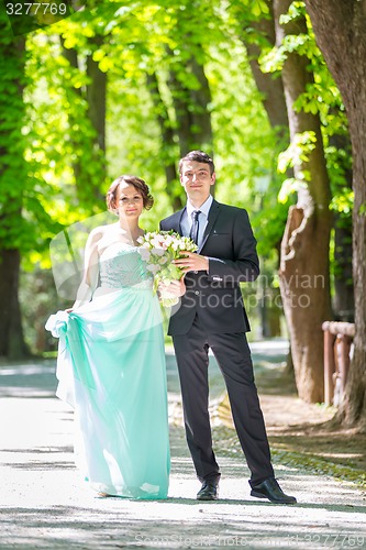 Image of Wedding couple walking in park.