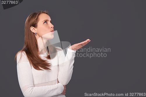 Image of Profile portrait of a woman blowing on palms