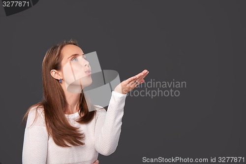 Image of Profile portrait of a woman blowing on palms