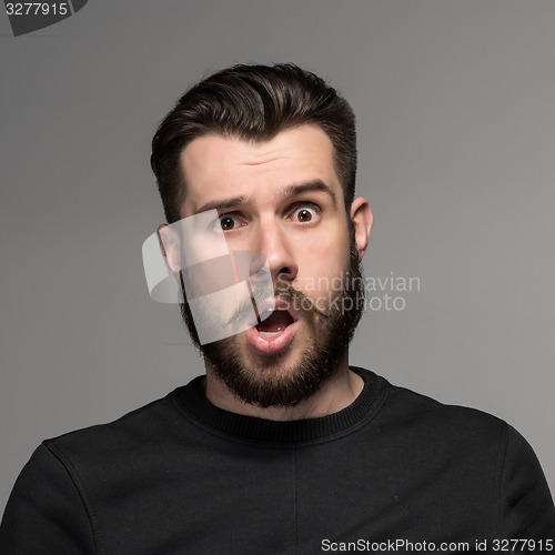 Image of Portrait of a young puzzled businessman with opened mouth