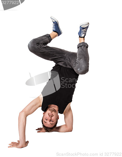 Image of Break dancer doing one handed handstand against a white background