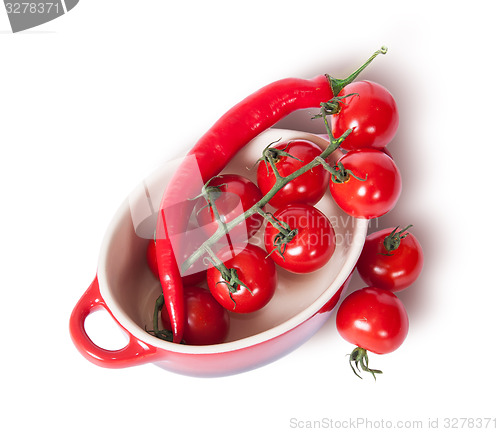 Image of Cherry tomatoes and chili peppers in the saucepan top view