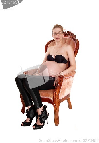 Image of Pregnant white woman in armchair.