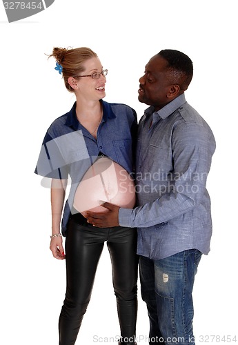 Image of African man holding baby belly of white girl.