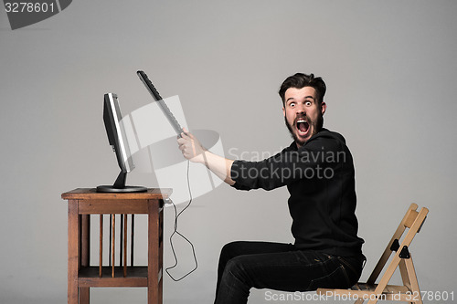 Image of Angry man is destroying a keyboard