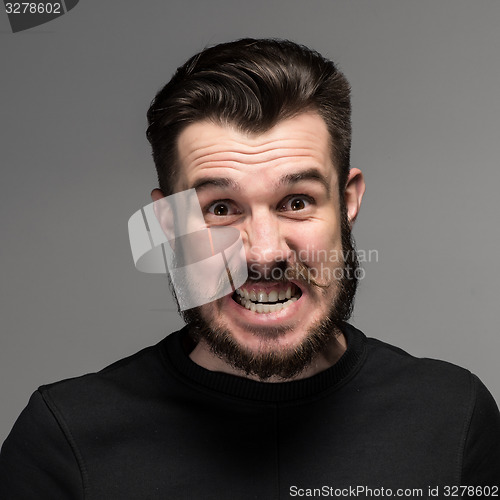 Image of Portrait of young fierce man in studio