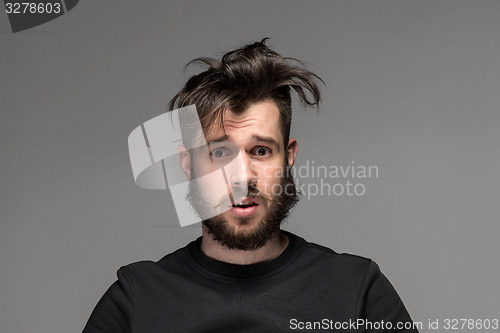 Image of Portrait of young tousled man in studio