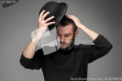 Image of Young man raising his hat  in respect and admiration for someone 