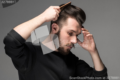 Image of young man comb his hair