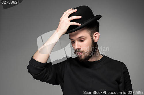 Image of Young man raising his hat  in respect and admiration for someone 