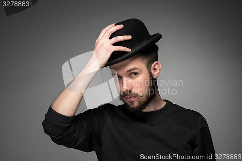 Image of Young man raising his hat  in respect and admiration for someone 