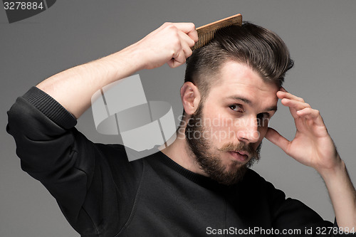 Image of young man comb his hair