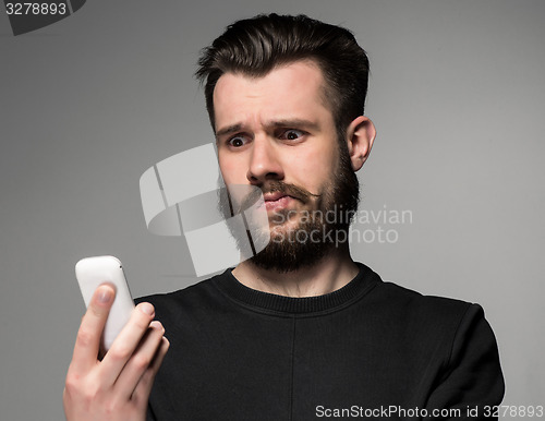 Image of Portrait of puzzled man talking on the phone