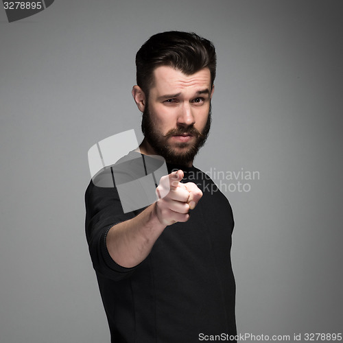 Image of Young man with beard and mustaches, finger pointing towards the camera