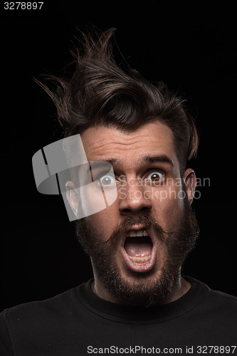 Image of Portrait of young tousled man in studio