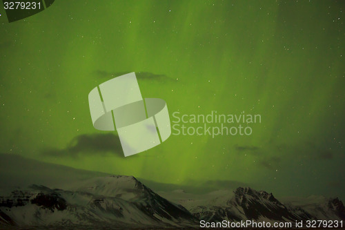 Image of Northern lights with snowy mountains in the foreground