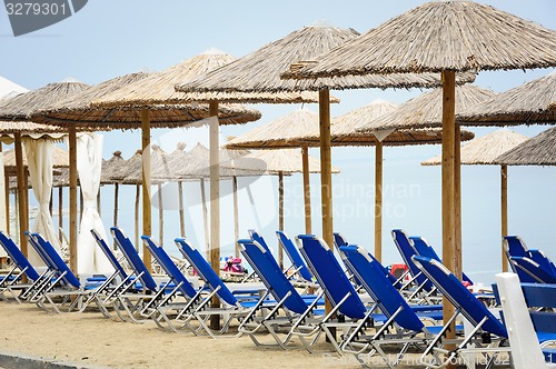 Image of Reed umbrellas and deck chairs at the beach