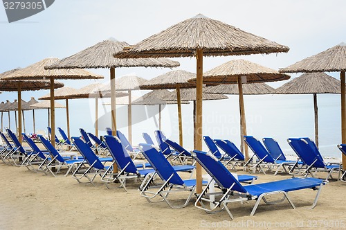 Image of Reed umbrellas and deck chairs at the beach