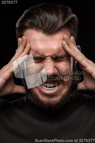 Image of Stressed businessman with a headache over black