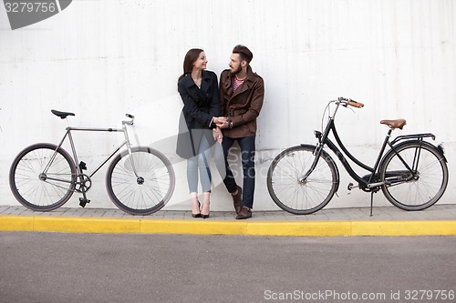 Image of Young couple standing against the wall and hugging