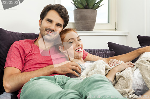 Image of Couple Resting on the Sofa at the Living Room