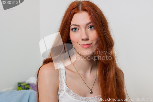 Image of Woman Stretching her Arms While Sitting on Bed